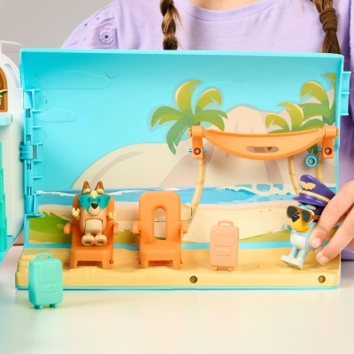 Brinquedo de cenário de praia com figuras e malas.