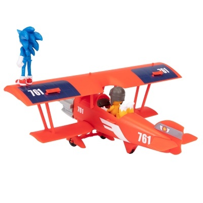 Avião de brinquedo vermelho e azul com figuras humanas e azul em cima da asa.