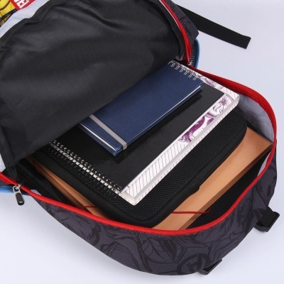 Mochila preta com detalhe vermelho aberta com cadernos e estojo dentro