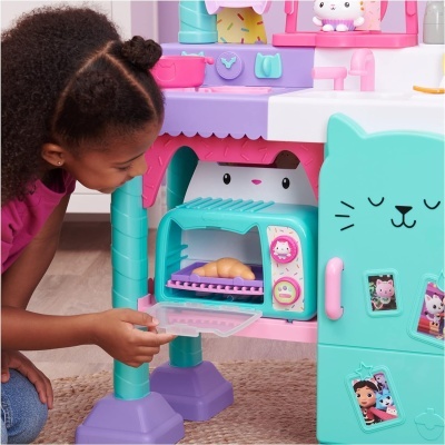 Brinquedo de cozinha infantil colorido com forno e porta em forma de gato, criança a brincar