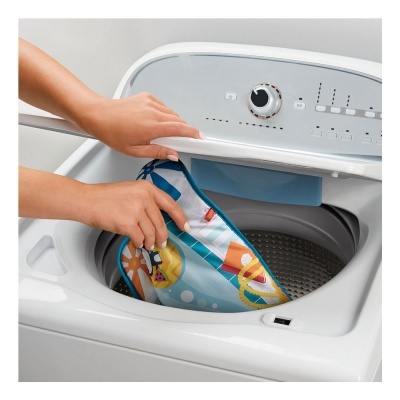 Máquina de lavar roupa branca com manta colorida sendo colocada dentro