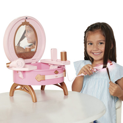 Brinquedo de penteadeira infantil rosa com espelho e acessórios, menina a usar modelador de cabelo.