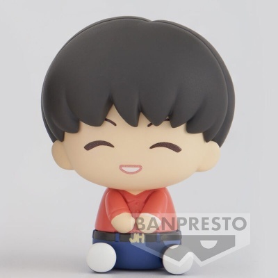 Figura chibi com cabelo preto e camisa vermelha sentada de pernas cruzadas