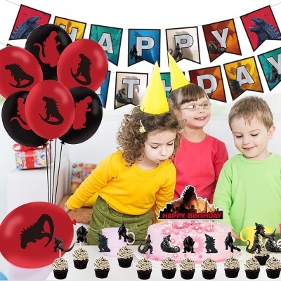 Crianças em festa de aniversário com decoração de dinossauros, bolo rosa, cupcakes e balões vermelhos e pretos.