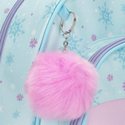 Chaveiro pompom rosa pendurado em mochila azul com padrão de flocos de neve