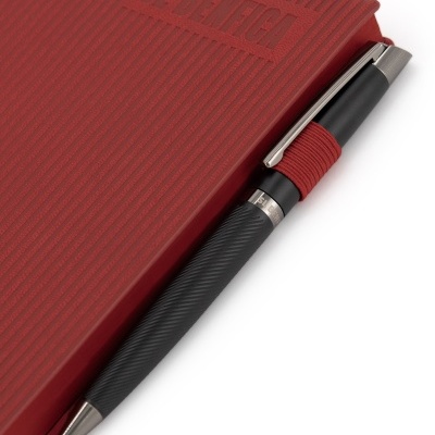Caderno vermelho texturado com relevo S. BENEGA e caneta preta com suporte vermelho