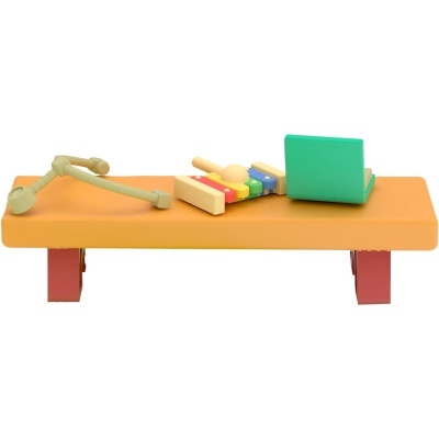 Mesa baixa com xilofone colorido, livro verde e braço articulado em fundo branco