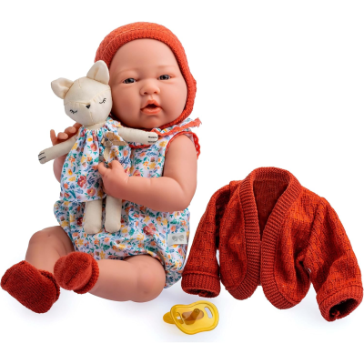 Boneca bebé com roupa floral e acessórios vermelhos, segurando boneco de tecido