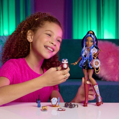 Criança a brincar com boneca estilizada e miniaturas em mesa branca