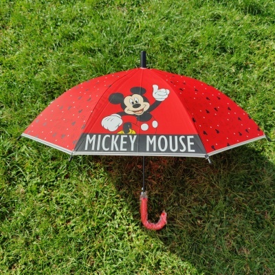 Guarda-chuva vermelho com desenho do Mickey Mouse e texto MICKEY MOUSE ao ar livre na relva
