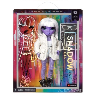 Boneca Shadow High com pele roxa, cabelo branco curto e casaco branco dentro de embalagem colorida