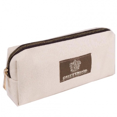 Estojo bege em tecido com fecho zip dourado e etiqueta GRYFFINDOR castanha e branca