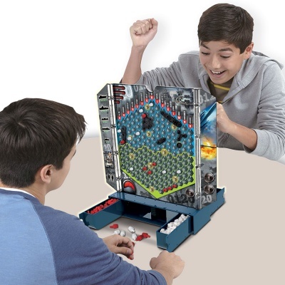 Crianças a jogar jogo de tabuleiro vertical com peças coloridas