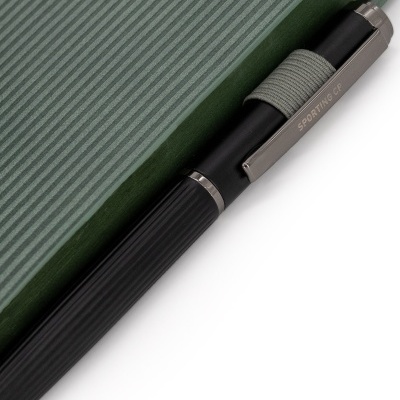 Caneta preta com clip metálico SPORTING CP sobre superfície verde texturada