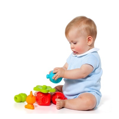 Bebé com roupa azul clara a brincar com brinquedos coloridos no chão