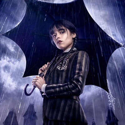 Mulher com blazer riscas e guarda-chuva preto sob chuva à noite