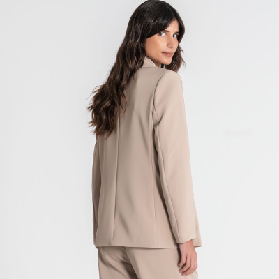 Blazer feminino bege visto de costas com calças combinando.