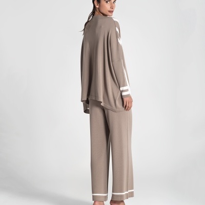 Conjunto de roupa bege feminino com calças largas e casaco oversized, riscas brancas, sapatos de salto branco