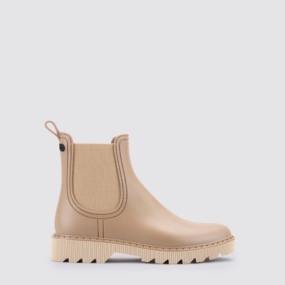 Bota Chelsea bege com sola branca sobre fundo cinzento claro