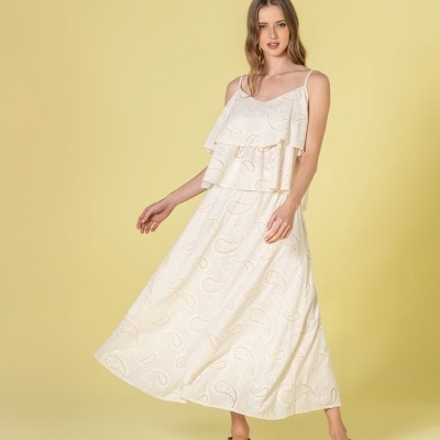 Vestido midi branco com padrão em relevo e alças finas, usado por mulher com sandálias castanhas.