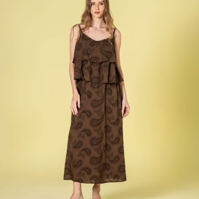 Vestido comprido castanho com padrão tribal preto e folhos, usado por modelo