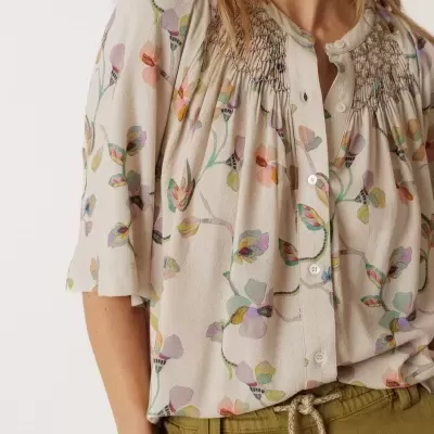 Blusa feminina bege com estampa floral e calças verdes com cordão trançado