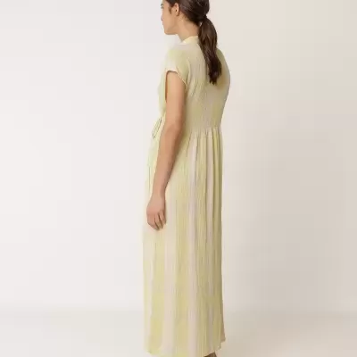 Vestido comprido amarelo e branco com cinto, usado com sapatilhas brancas