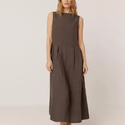 Mulher com vestido castanho escuro sem mangas e sapatos castanhos escuros.