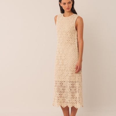 Vestido longo bege de croché com padrão floral usado por mulher