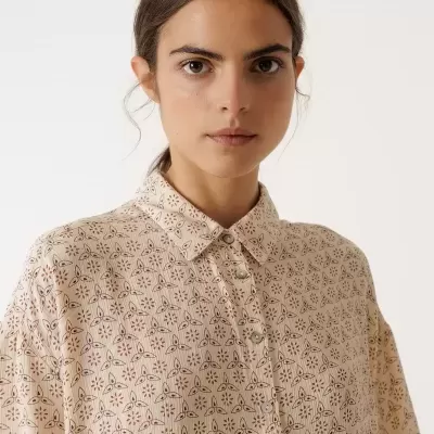 Camisa bege claro com padrão geométrico e botões