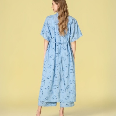 Vestido comprido azul claro com recortes em padrão de folhas visto de costas.