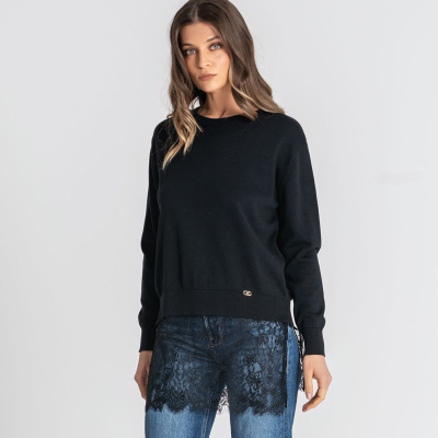 Camisola preta de manga comprida com calças de ganga azul com renda preta na parte superior.