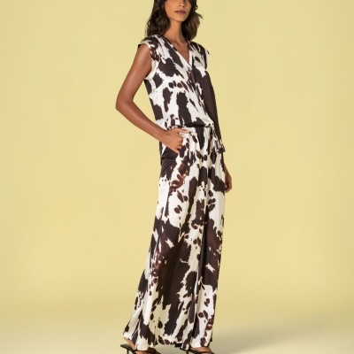 Modelo a usar vestido comprido sem mangas preto e branco com padrão abstrato