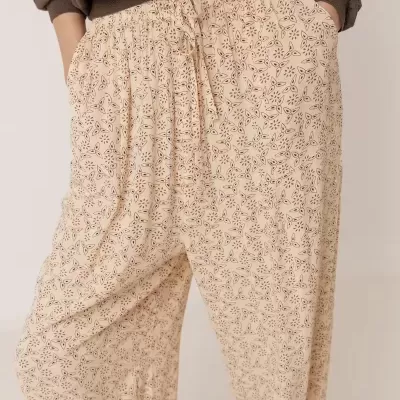 Calças creme com padrões florais e camisola castanha