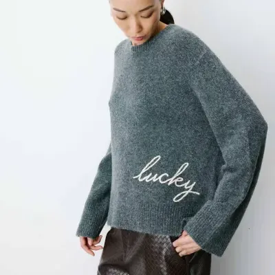 Camisola cinza felpuda com texto branco lucky e calças castanhas texturizadas