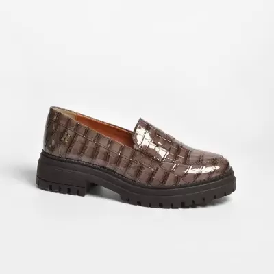 Sapato mocassim castanho com padrão de pele de crocodilo e sola preta.