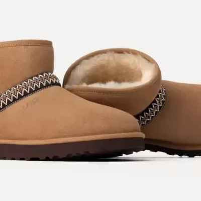 Par de botas castanhas forradas com pelo branco e faixa decorativa preta e branca