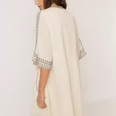 Vestido curto branco com bordado preto, visto de costas