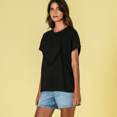 Mulher a usar t-shirt preta com coração em tecido e calções de ganga