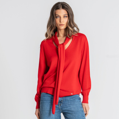 Camisola vermelha com laço no decote e jeans azul