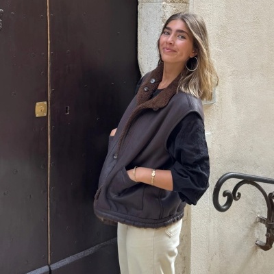 Mulher vestindo colete acolchoado castanho escuro com gola de pêlo castanho claro