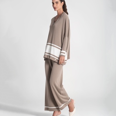 Conjunto feminino bege de malha com riscas brancas e sapatos brancos de tacão