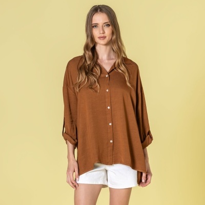 Camisa castanha feminina com botões, mangas enroladas, combinada com calções brancos