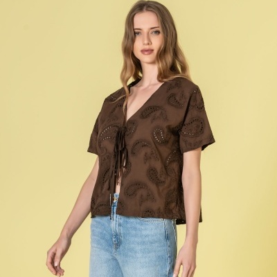 Blusa castanha com padrão paisley e recortes, decote em V com cordões, usada com jeans azuis claros