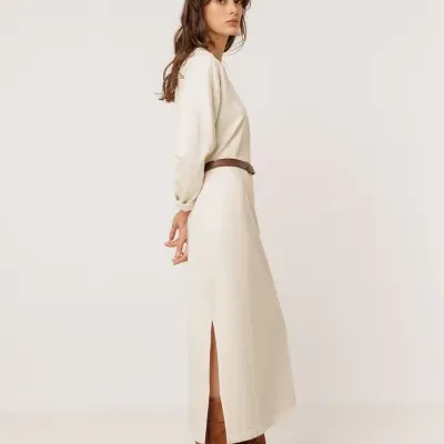Modelo com vestido longo creme e botas castanhas