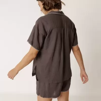 Conjunto feminino de pijama castanho escuro, visto de costas.