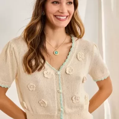 Camisola de malha bege clara com flores 3D e detalhes em verde-água, usada com calças verde-água.