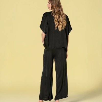 Modelo de costas com conjunto preto em fundo amarelo