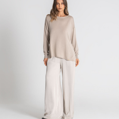 Mulher com roupa casual bege e branca em fundo branco