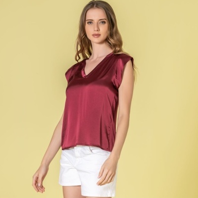 Top feminino acetinado vinho com decote em V e calções brancos em fundo amarelo